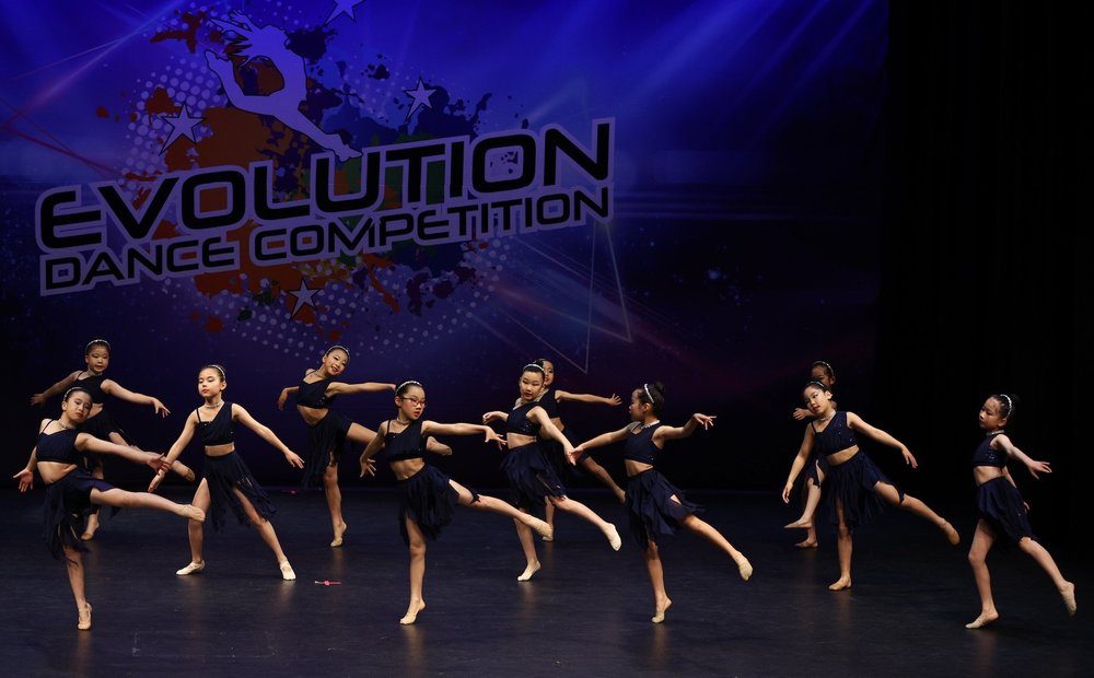 Group performance on stage at Evolution Dance Competition