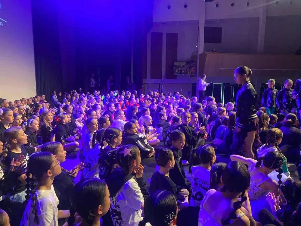 Audience and dancers under purple light