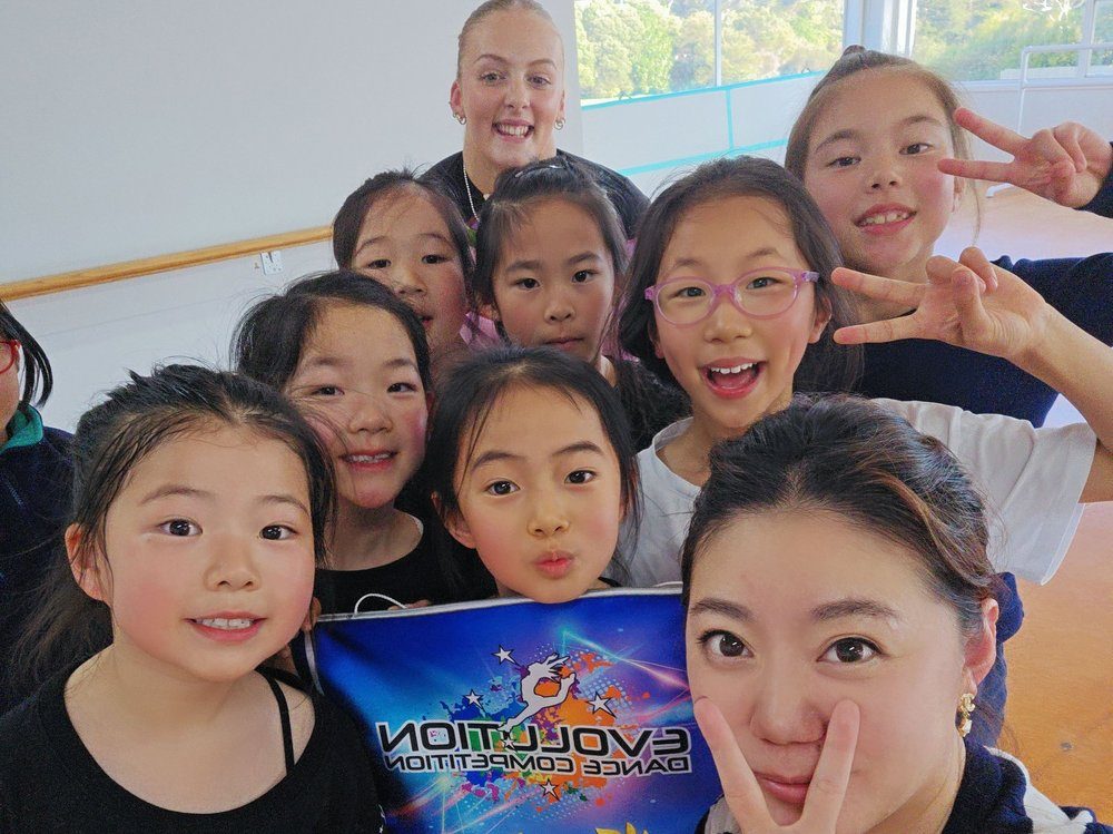 Students and teacher smiling backstage